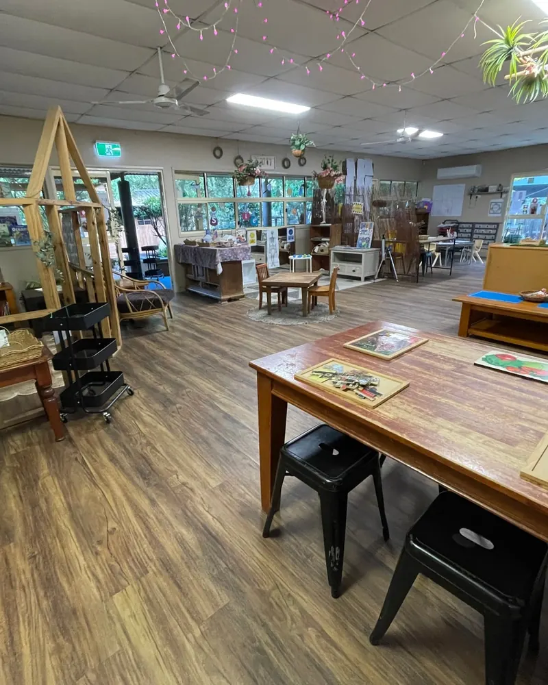 An open, light-filled room with timber tables and play spaces