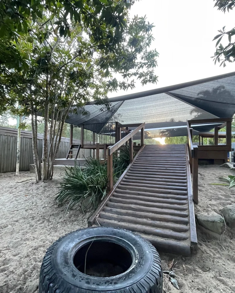 A wide timber ramp leading up to a shaded deck in the outdoor play yard